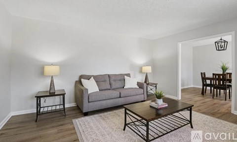 A living room with a grey couch, a coffee table, and two side tables with lamps.