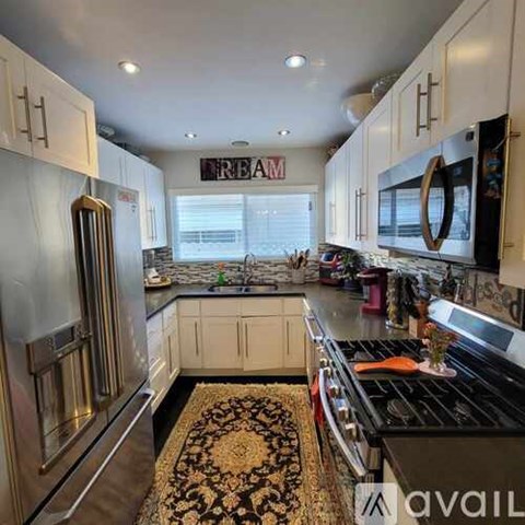 A kitchen with white cabinets and a black stove top.