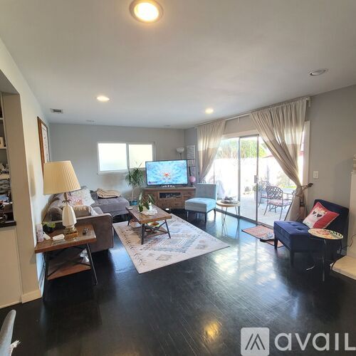 A living room with a television, couch, and a rug.