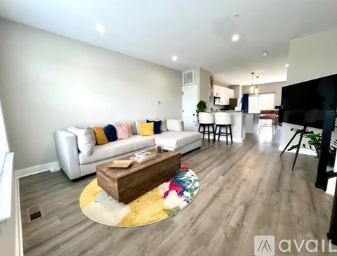 A living room with a white couch and a wooden coffee table.