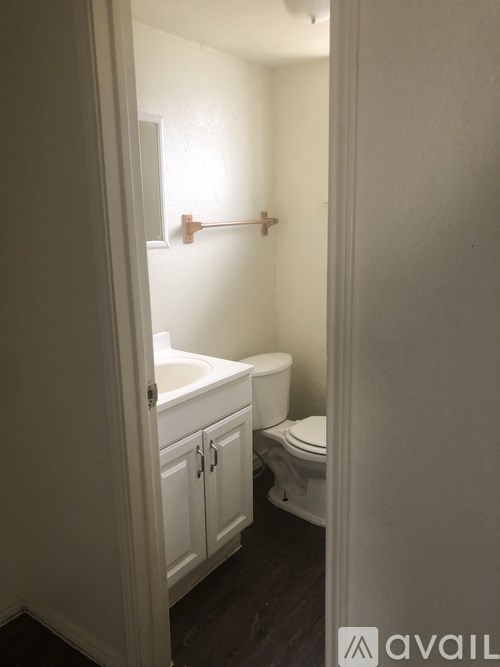 A bathroom with a toilet, sink and cabinet.