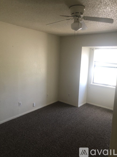 A room with a ceiling fan and a window.