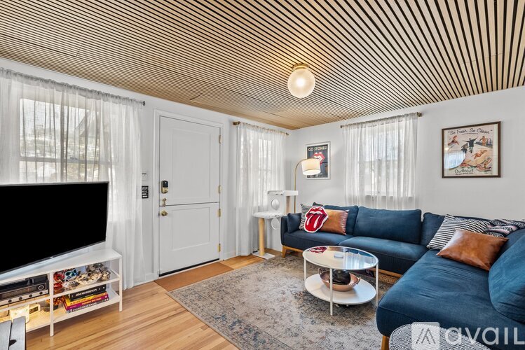 A living room with a blue couch and a television.