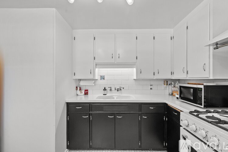 A kitchen with black cabinets and white walls.