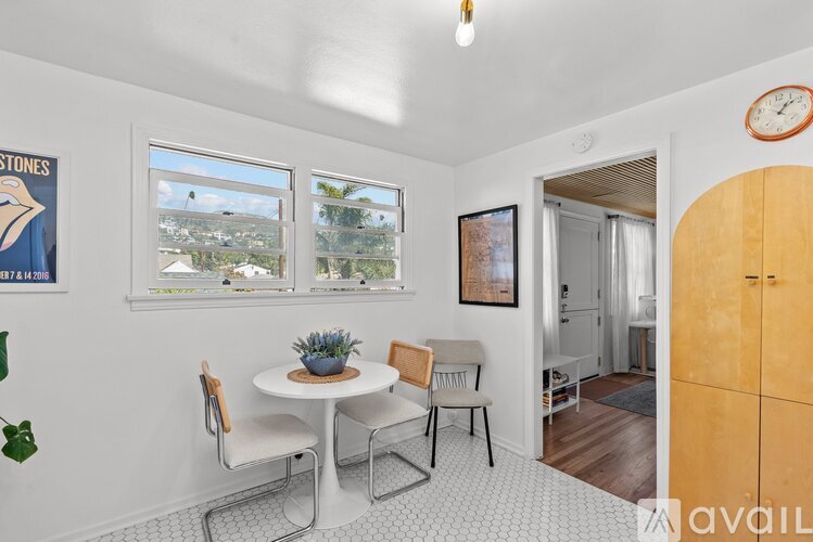 A dining room with a table set for two and a view of the outside.