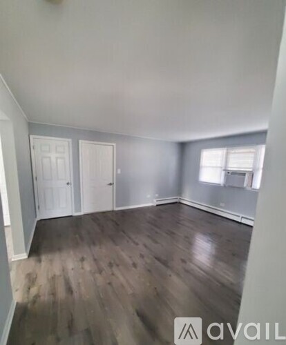 A room with wooden flooring and white doors.