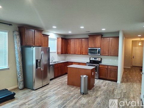 A kitchen with wooden cabinets and a refrigerator.