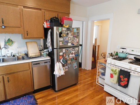 A kitchen with a refrigerator covered in magnets and a stove with pots on it.