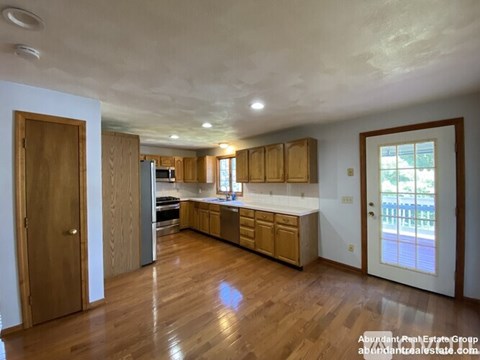 A kitchen with wooden cabinets and a refrigerator.