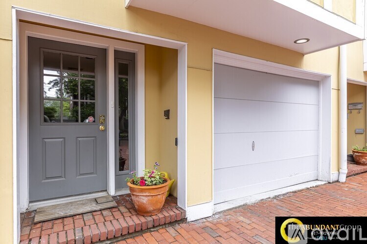 A house with a grey door and a white garage door.