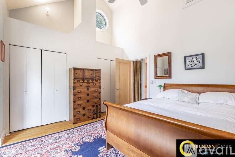 A bedroom with a bed, dresser, and mirror.
