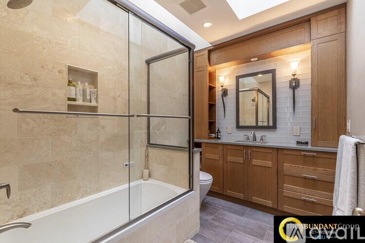 A bathroom with a glass shower door and a bathtub.
