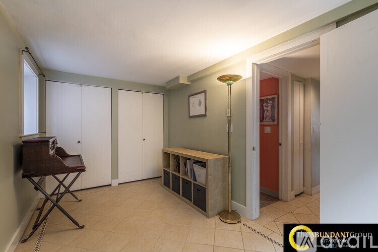 A room with a desk, chair, and a lamp.