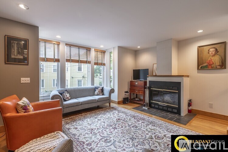 A living room with a fireplace and a painting on the wall.