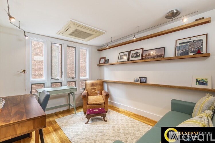 A living room with a green couch, a brown chair, and a wooden table.