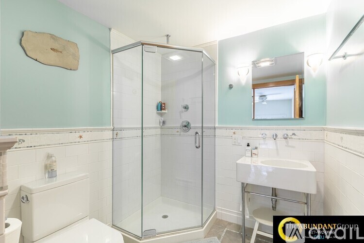 A bathroom with a toilet, sink, and shower.