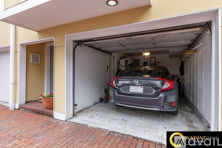 A car is parked in a garage attached to a house.