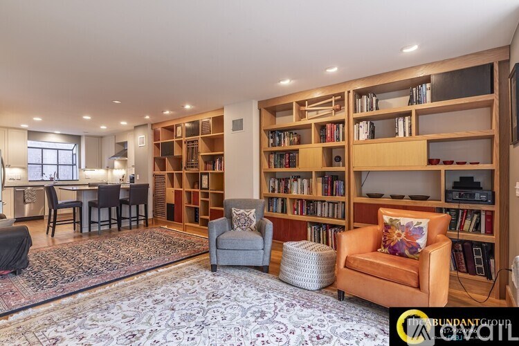 A living room with a large bookshelf filled with books.