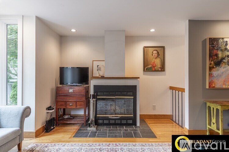 A living room with a fireplace and a painting on the wall.