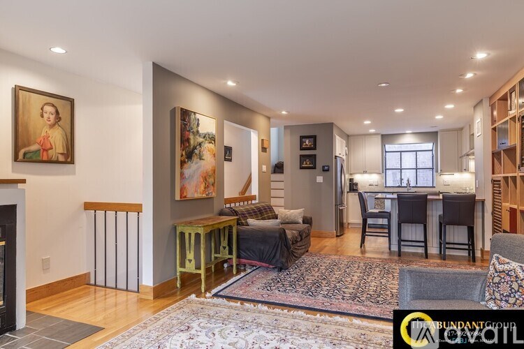 A living room with a fireplace and a painting on the wall.