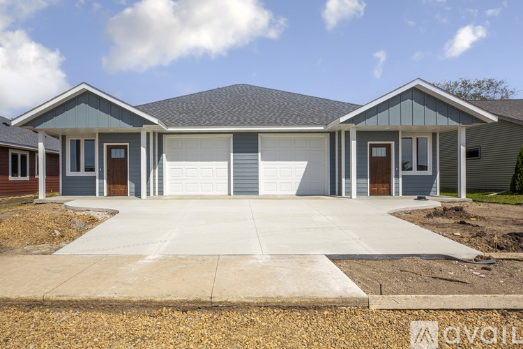 A house with a grey roof and a white garage door.