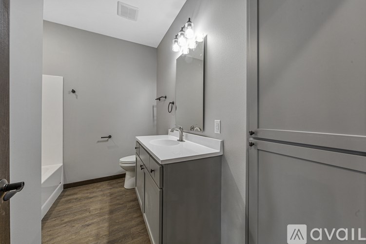 A bathroom with a sink, mirror, and toilet.