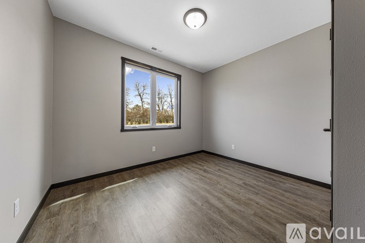 A room with a window and wooden flooring is available for rent.