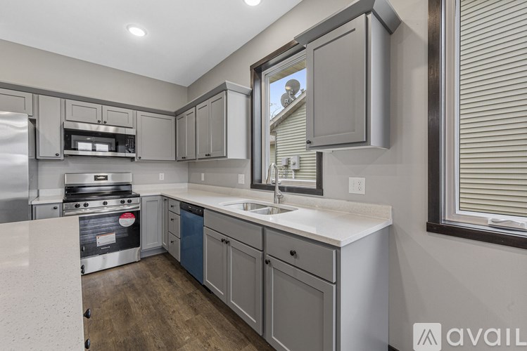 A modern kitchen with a stainless steel refrigerator and a white countertop.