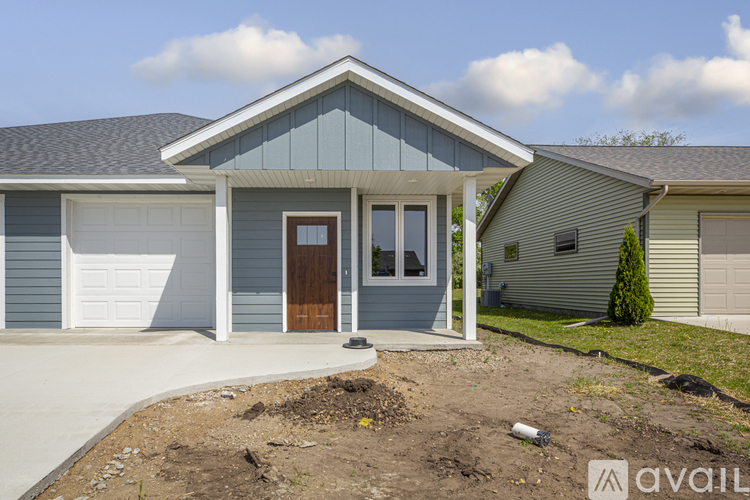 A house with a blue front and a brown door is for sale.