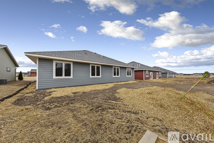 A row of houses with a blue sky and clouds in the background.