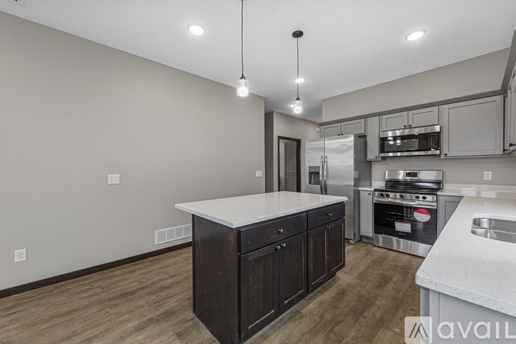 A kitchen with a white countertop and dark wood cabinets.