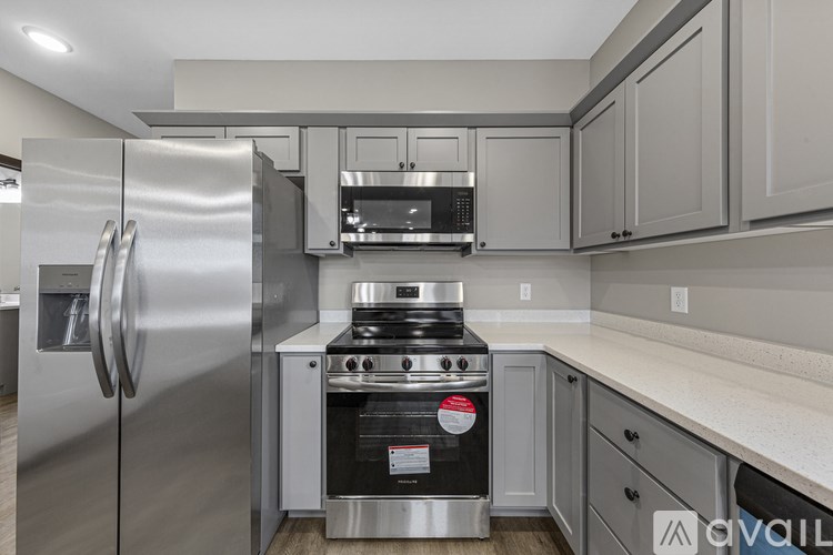 A modern kitchen with a stainless steel refrigerator and oven.