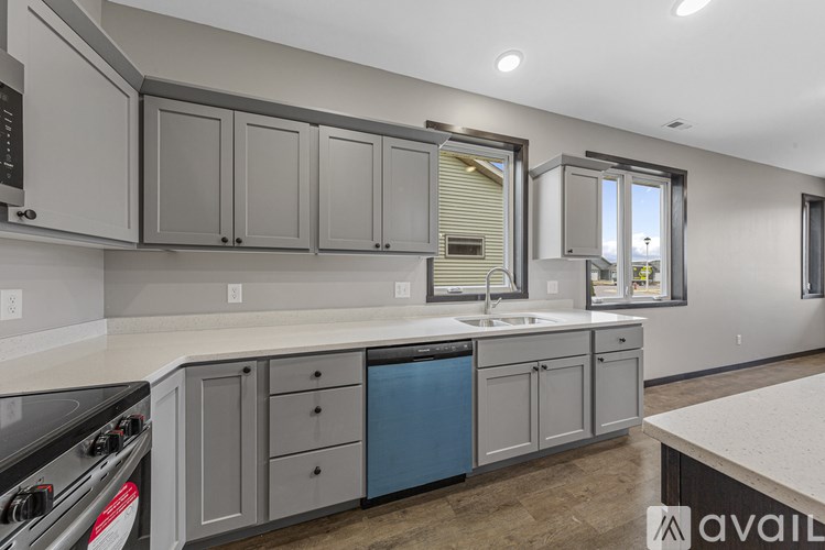 A kitchen with grey cabinets and a blue dishwasher.