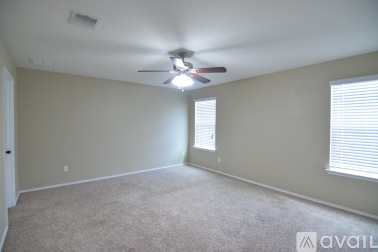 A room with a ceiling fan and a door.