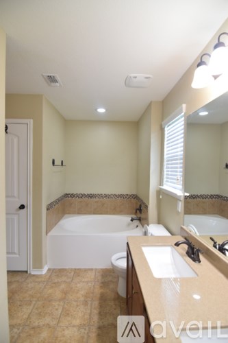 A backyard with a wooden fence and a grassy area.