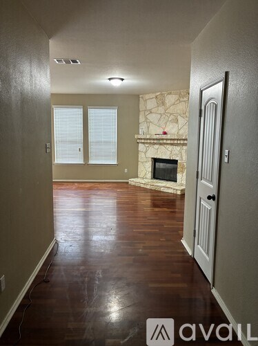 A room with a fireplace and wood flooring.