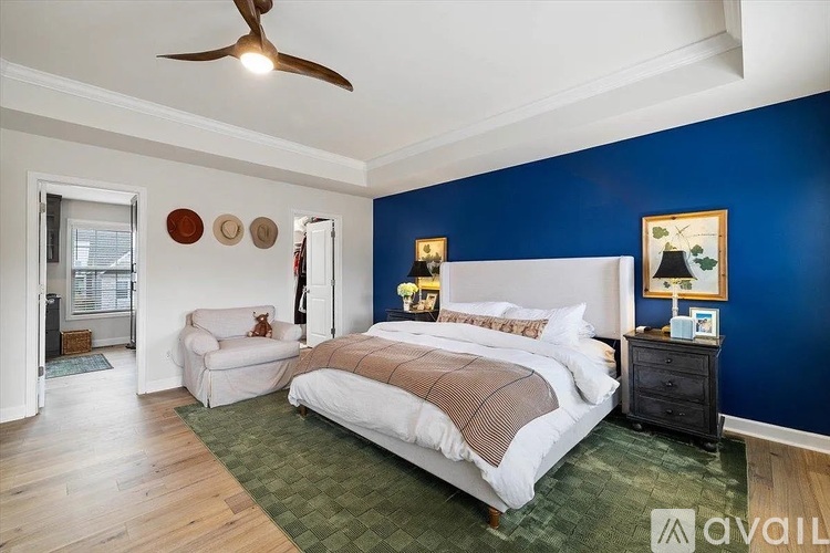 A bedroom with a bed, a ceiling fan, and a wooden crate coffee table.