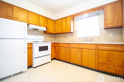 A kitchen with wooden cabinets and a white refrigerator.