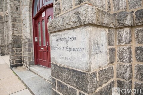 A stone wall with a red door and a sign that says "Gleeson".