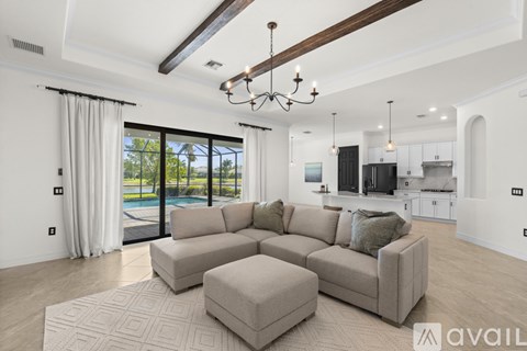 A modern living room with a large sectional sofa and a chandelier.