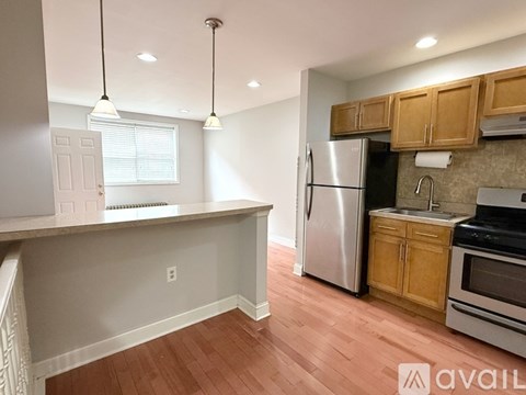 A kitchen with wooden cabinets and a stainless steel refrigerator.