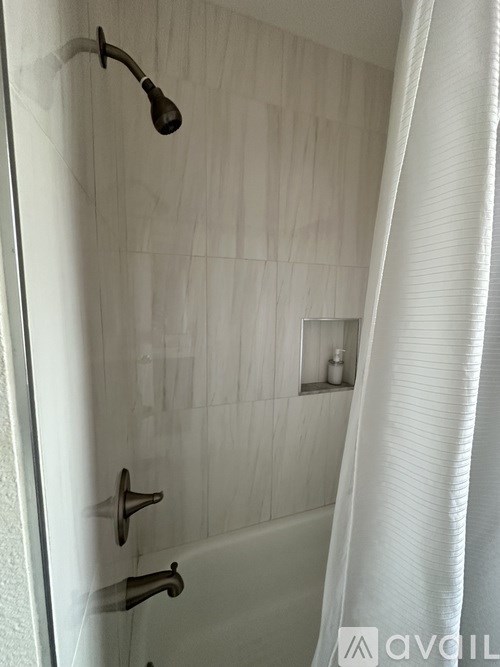 A white bathroom with a shower and a white curtain.