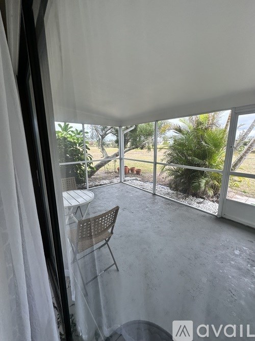 A patio with a table and chairs overlooks a garden.