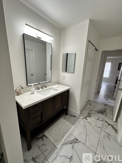 A bathroom with a marble floor and a white sink.