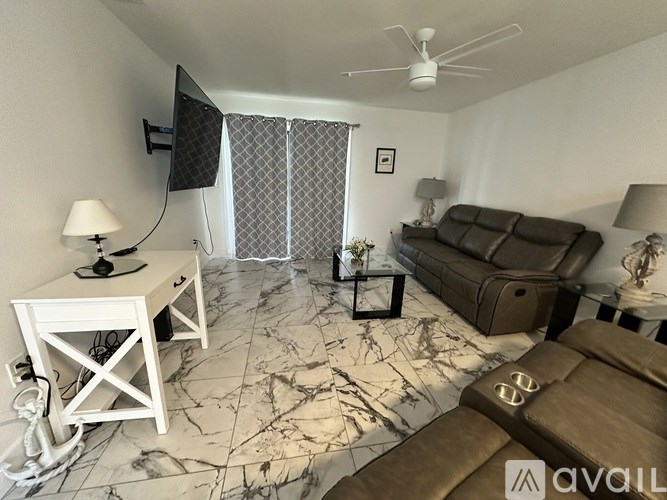 A living room with a brown couch and a white table.