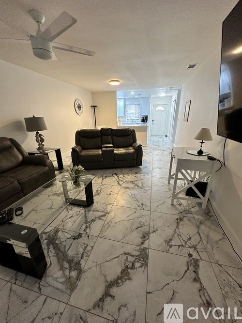 A living room with a brown couch and a marble floor.