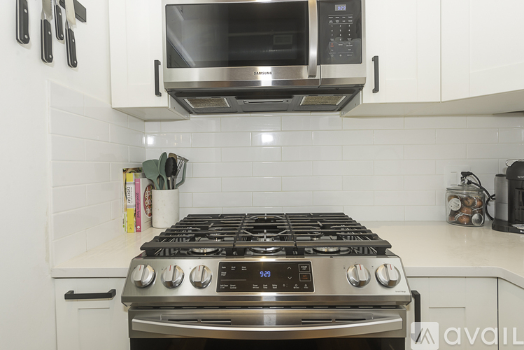 A modern kitchen with a stainless steel stove and microwave above it.