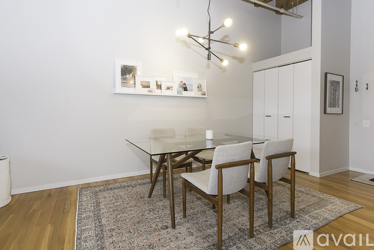 A modern dining room with a glass table and chairs.