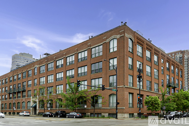 A large red brick building with a parking lot in front.