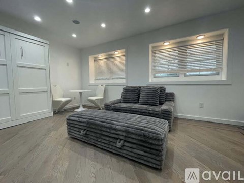 A living room with a grey sofa and a white cabinet.